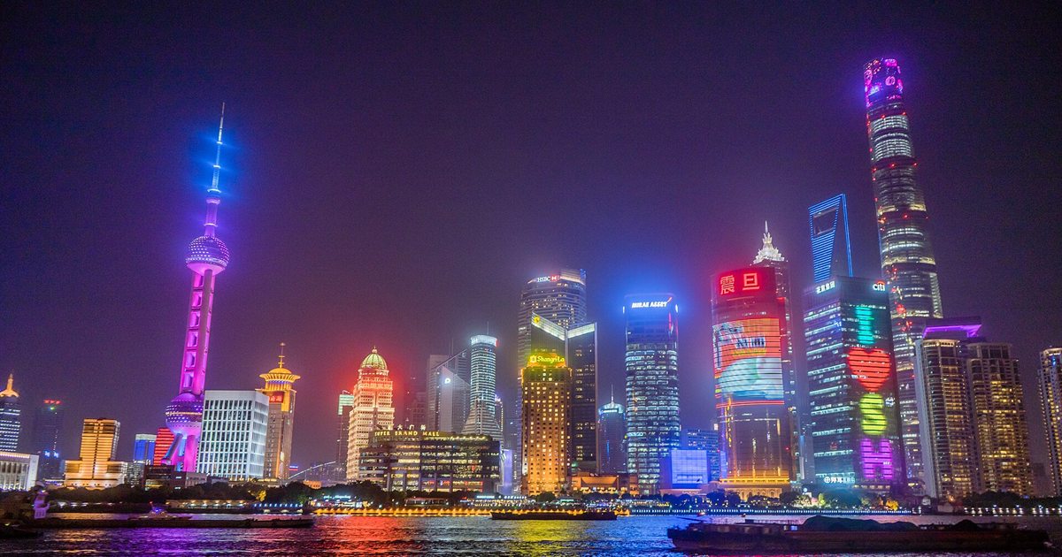 Shanghai's Lujiazui financial district skyline lit up in neon at night across the Huangpu River