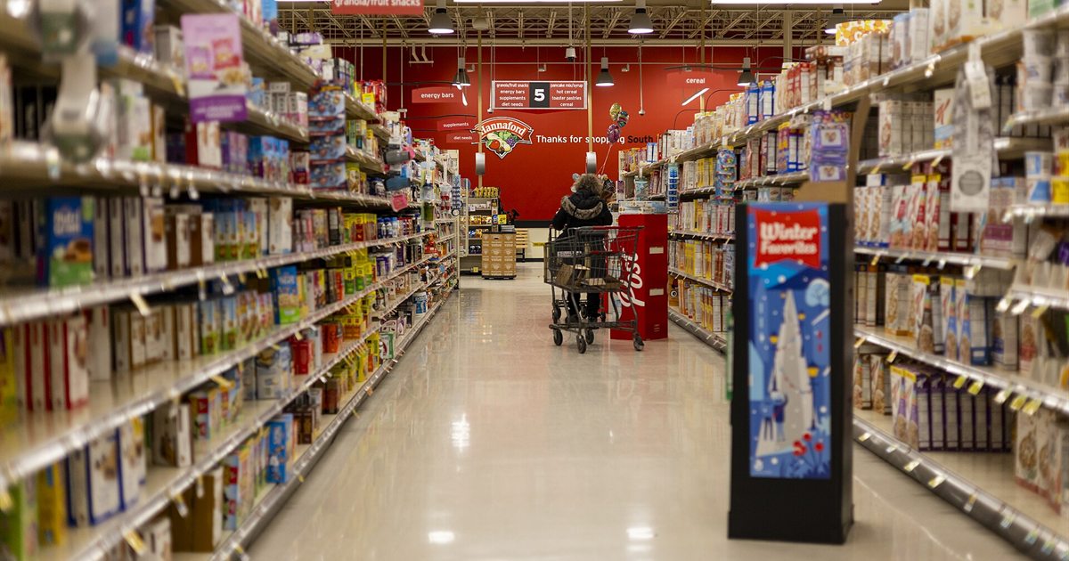 A long grocery store aisle with shelves of packaged food on both sides
