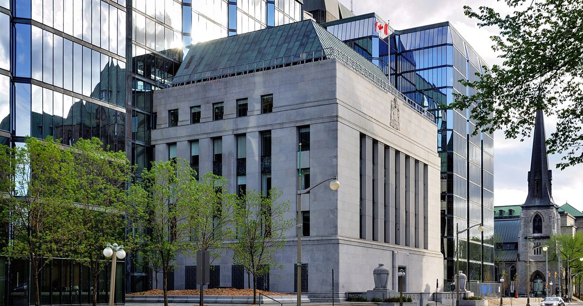 The Bank of Canada headquarters building in Ottawa with glass towers behind it