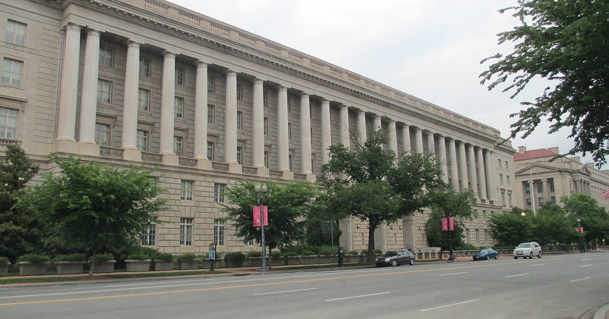 The Internal Revenue Service headquarters building on Constitution Avenue in Washington, D.C., with trees along the sidewalk