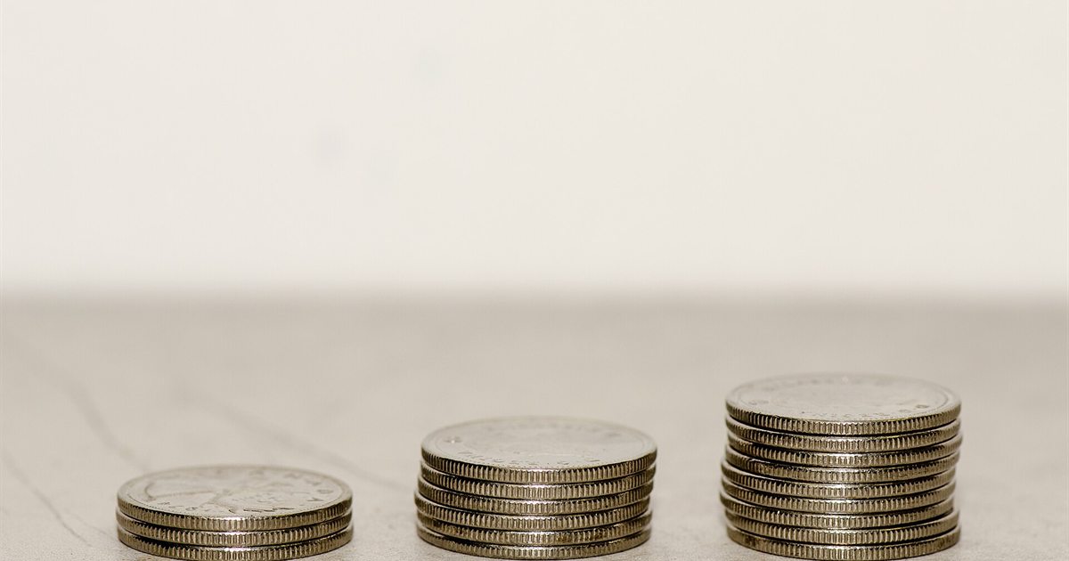 Three stacks of Canadian coins growing in height on a white surface