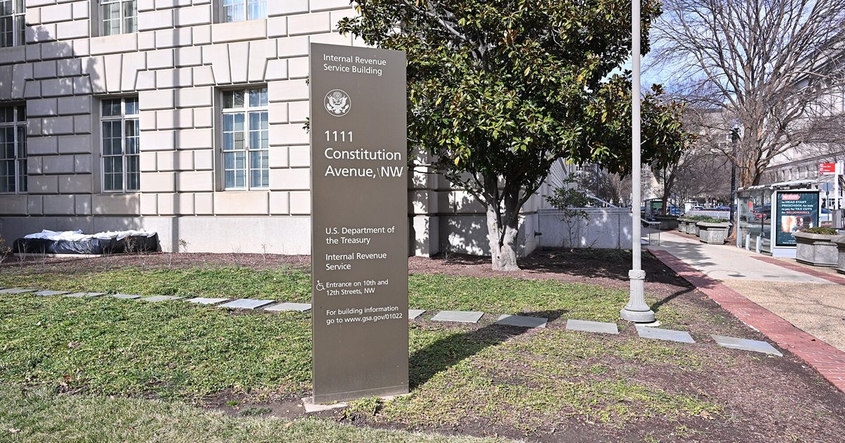 A fork in the road with signs reading Roth and Traditional and a tax form