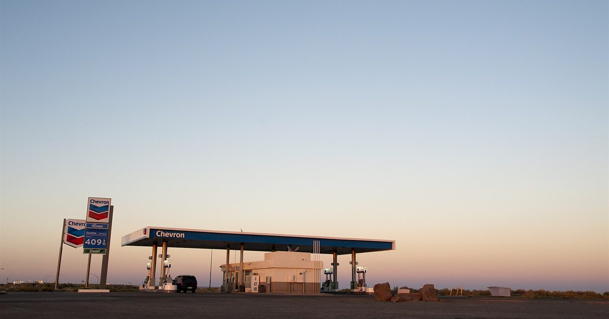 A Chevron gas station in Toronto at dusk with its price sign lit