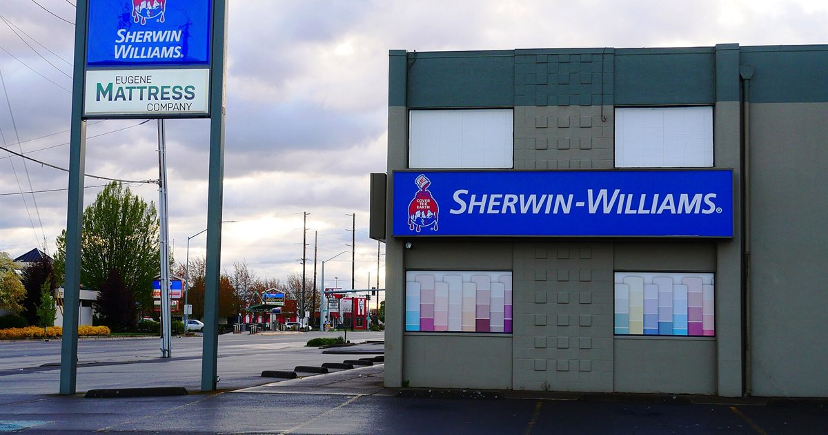 A Sherwin-Williams paint store with a blue sign and colour swatches in the windows in Eugene, Oregon