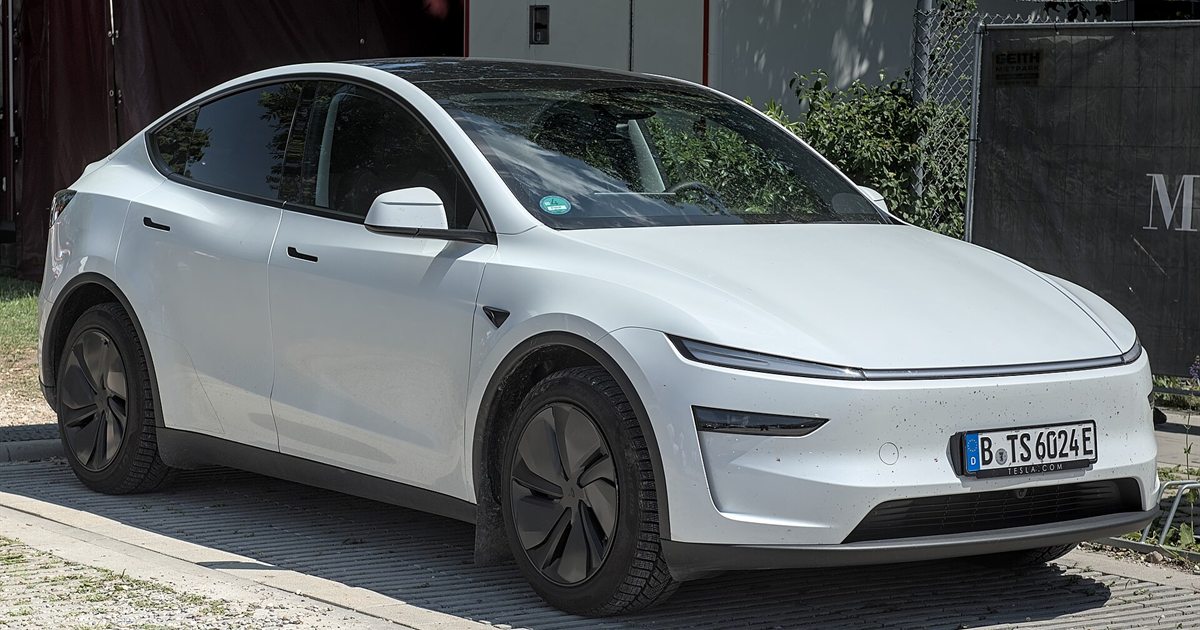 A white Tesla Model Y parked on a street