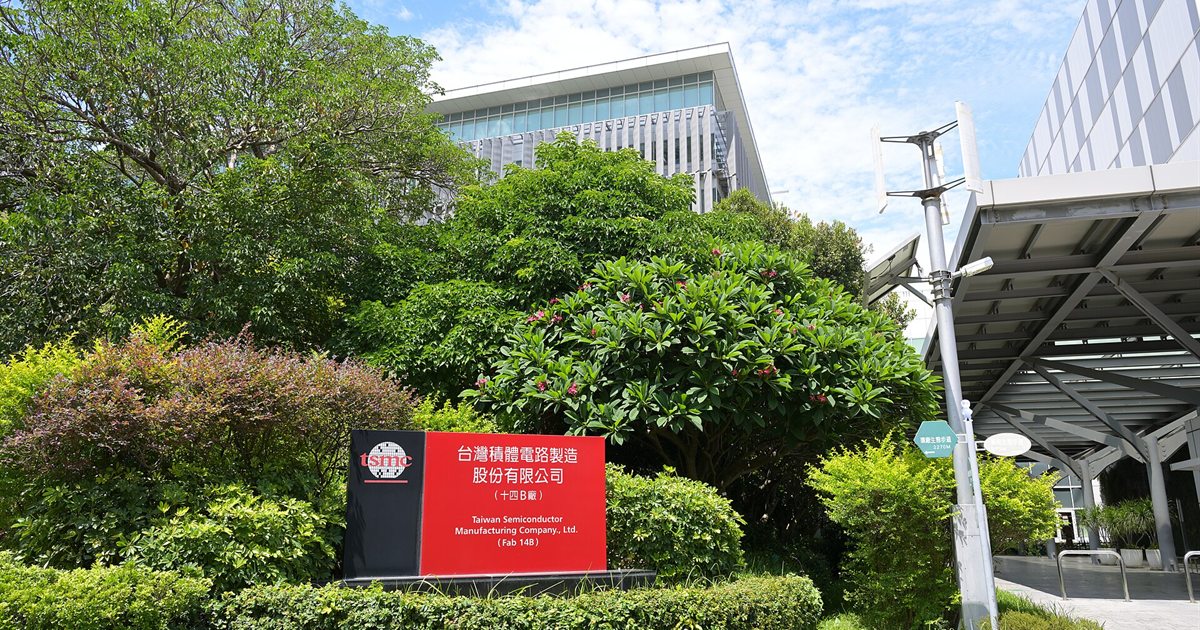 The entrance sign and buildings of TSMC Fab 14B in Tainan, Taiwan, surrounded by trees